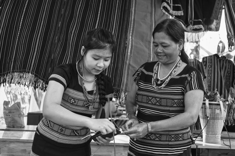 Người mẹ Hrê truyền dạy con gái cách gói bánh lá đót.